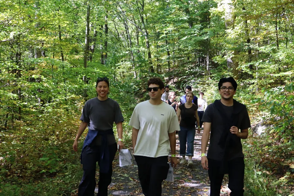 Teammates walking side by side down a wooded trail